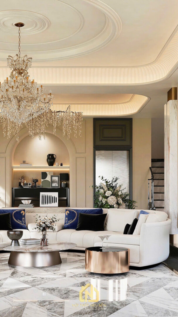 Phòng khách biệt thự nổi bật với sofa trắng, đèn chùm pha lê và hệ trần cong hắt sáng sang trọng.